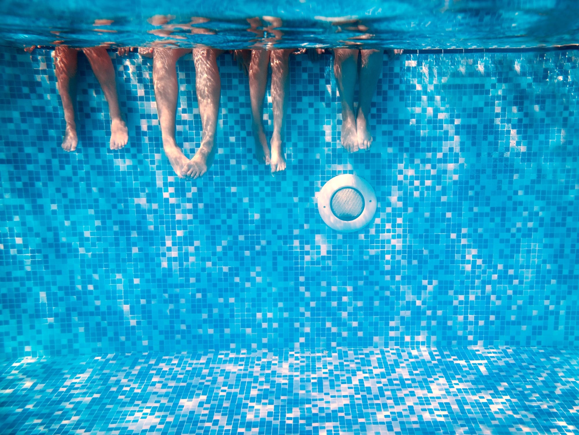 kids legs in swimming pool being aware of bacteria that can cause infections kids keep out of pool with high bacterial levels